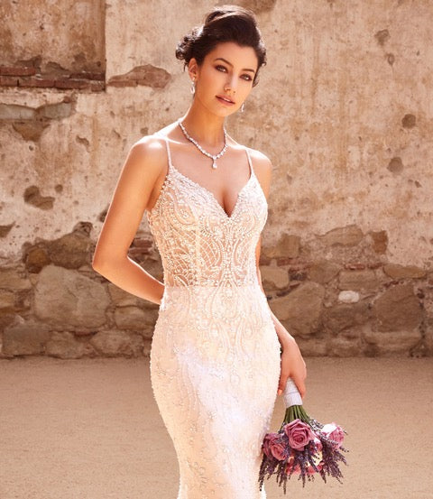 A Bride standing in front of a beautiful stone wall wearing Anna Bellagio jewelry.