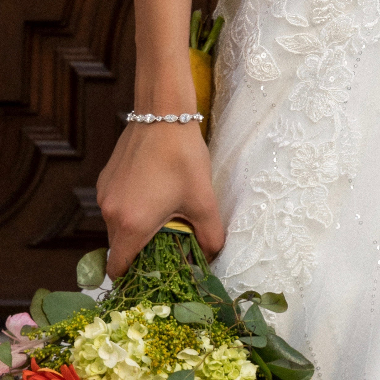 Airelle Cubic Zirconia Bracelet from Anna Bellagio on a wrist holding a bouquet