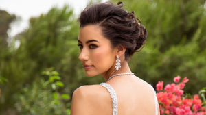 A beautiful bride standing in a garden wearing Anna Bellagio bridal earrings.