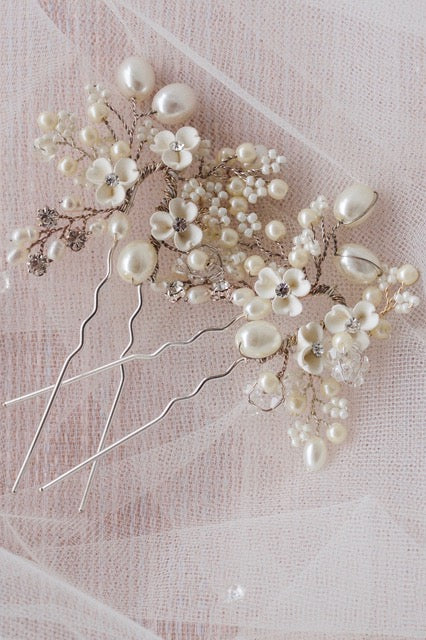Floral hair pins lying against white tull