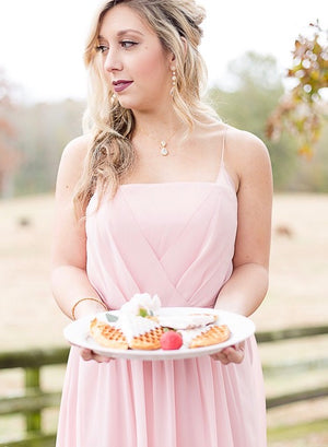 A bridesmaid wearing a pink bridesmaids gown wearing goldtone jewelry from Anna Bellagio.